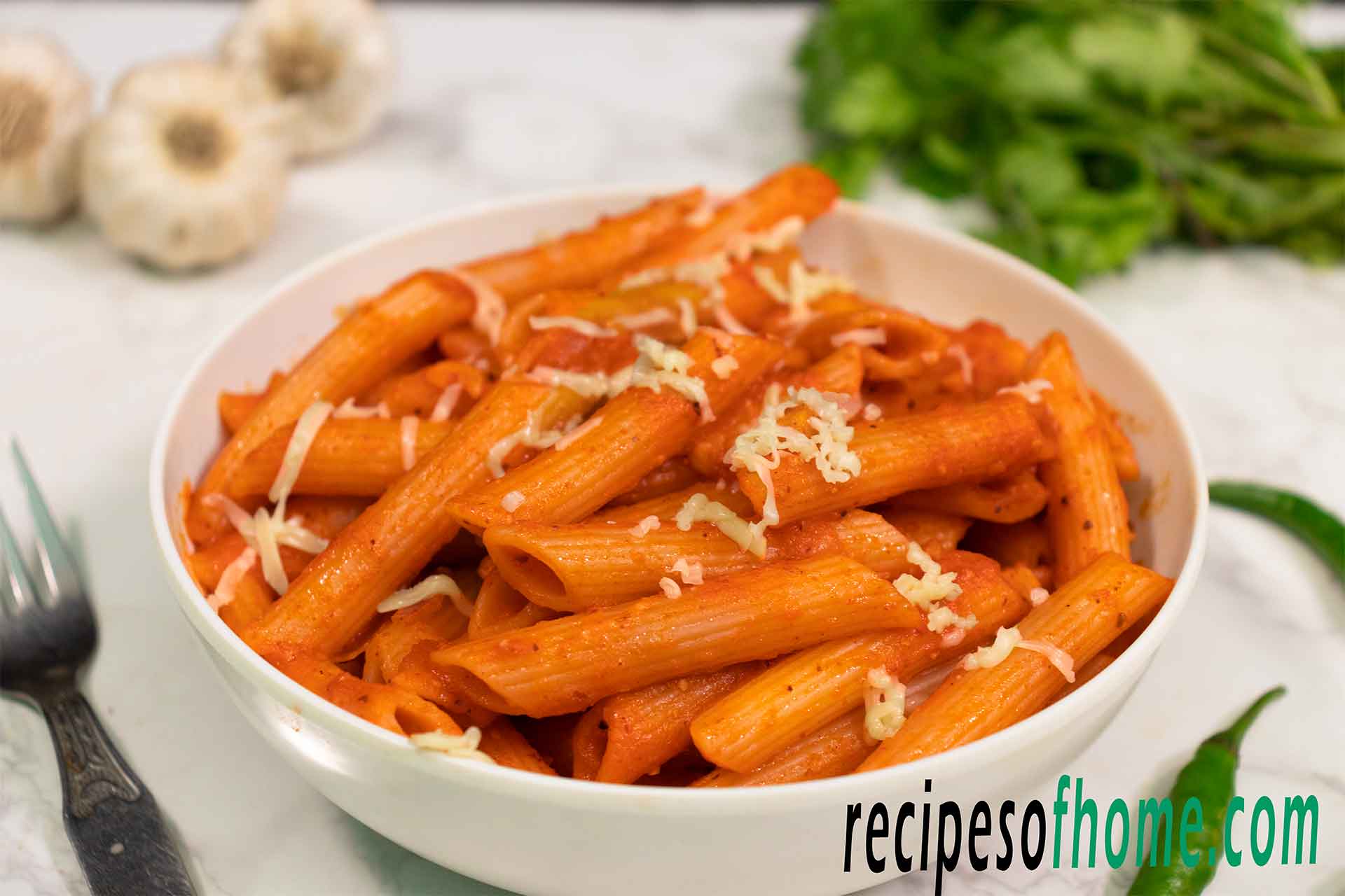 red sauce pasta recipe serve on white bowl garnish with grated cheese from top