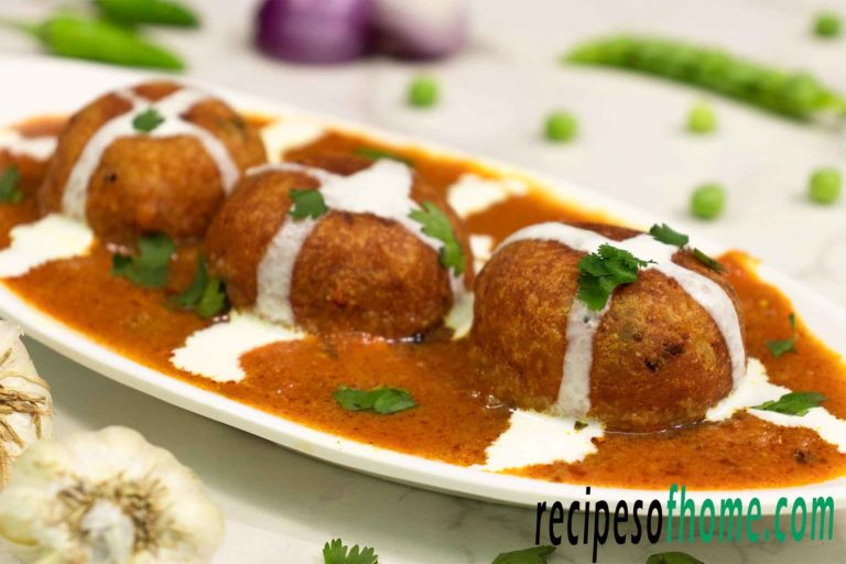 malai kofta recipe serve on white plate garnish with cream and freshly chopped coriander leaves