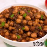 punjabi chole recipe serve on white bowl garnish with fresh coriander leaves